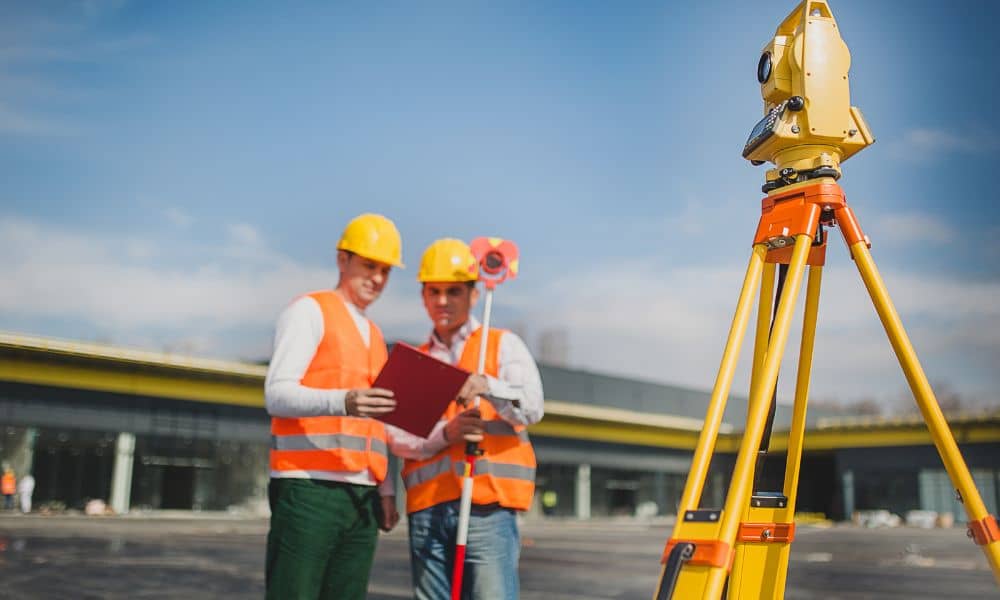 Surveyors reviewing site plans during an ALTA title survey at a commercial property