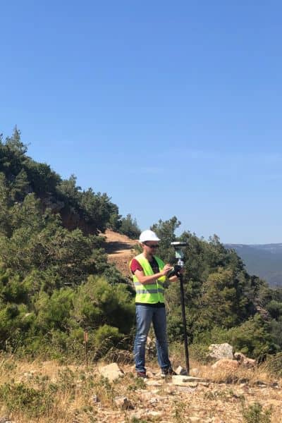 Surveyor using GNSS rover in open terrain, showing how solar storms can affect GPS accuracy during an ALTA land title survey

