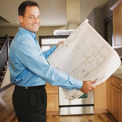 Professional reviewing detailed plans and blueprints for an ALTA title survey
