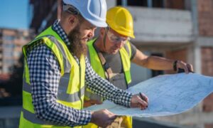 Surveyors reviewing plans on site during an alta land title survey to confirm easement locations